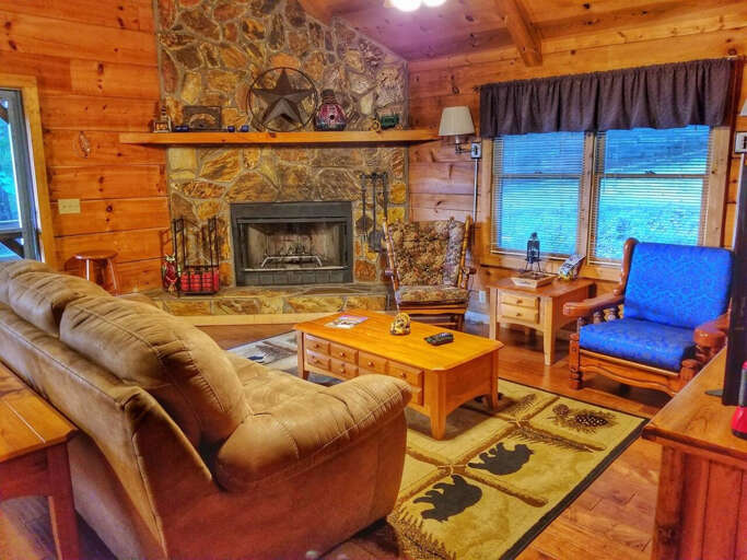 Living room with wood burning fireplace, sleeper sofa and flat screen tv